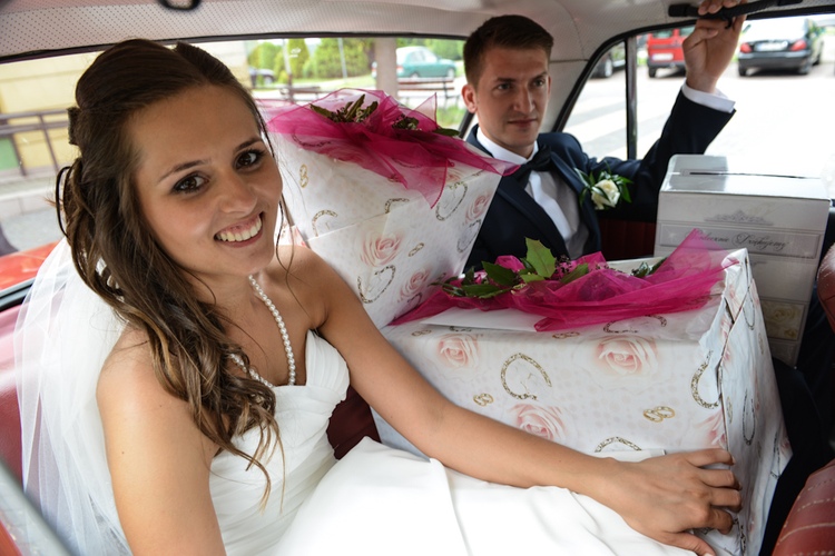 Młodzi z prezentami ślubnymi w samochodzie