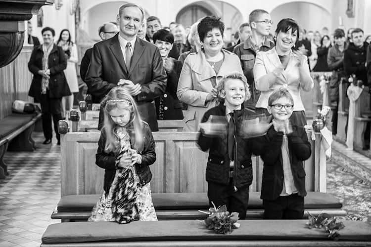 Rodzice pary młodej i dzieci radośnie wiwatujące w kościele podczas ślubu