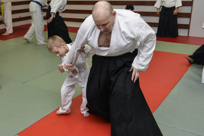 Dziecko i dorosły współnie ćwiczą technikę Aikido